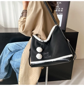 Detail of black PU tote bag featuring white fleece trim and decorative bow accents