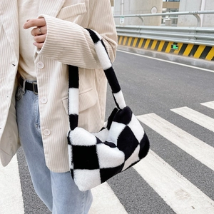 Detail of checkered plush shoulder bag with soft faux fur texture and beige strap