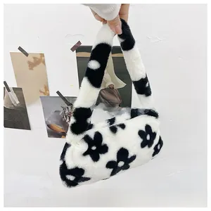 Detail of soft faux fur underarm bag with black and white floral sunflower pattern