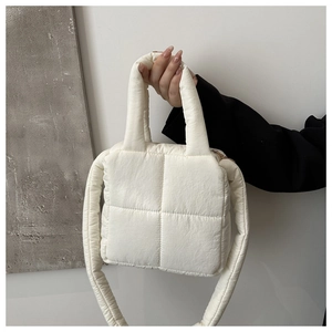 Dettaglio borsa trapuntata bianca con manici spessi e tracolla imbottita in peluche