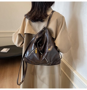 Detailed view of dark brown PU leather multi-pocket bag on a model wearing a light trench coat