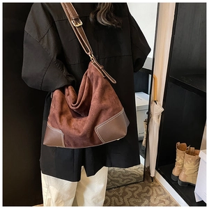 Detail of large brown matte PU leather tote bag with contrast stitching and adjustable strap