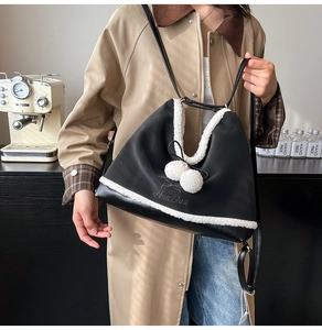 Detail showing black PU leather bag with white faux fur trim and decorative poms