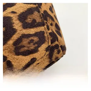 Detailed close-up showing the soft leopard print suede texture and fine stitching of the tote