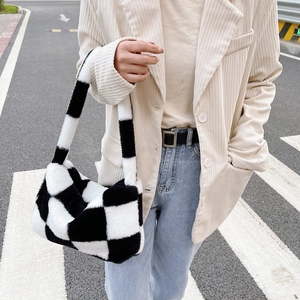 Close-up of fluffy black and white checkered plush shoulder bag in a street style look