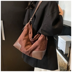 Detail of vintage brown tote bag showing textured matte suede and smooth leather patchwork