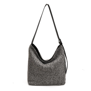 Minimalist grey wool texture hobo bag with black leather shoulder strap on white background