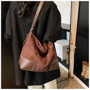 Detail view of large brown hobo bag featuring contrast stitching and matte suede finish