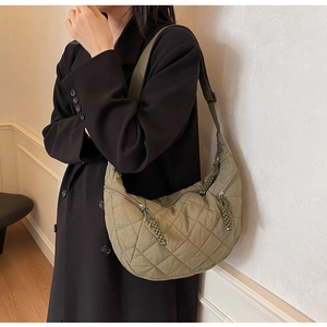 Detail of olive green quilted hobo bag featuring diamond stitching and zipper texture