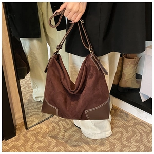 Detail of dark brown suede tote bag with contrast stitching and smooth leather accents
