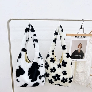 Detail of plush tote bags featuring cow print and floral patterns with wide straps