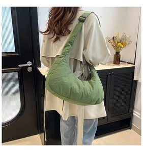 Detail showing avocado green quilted crescent bag with adjustable wide shoulder strap