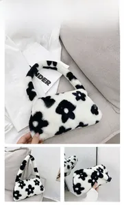 Detail view of plush black and white floral underarm bag with soft faux fur texture