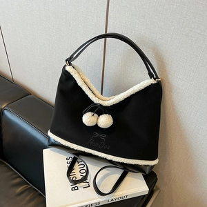 Chic black fabric tote bag with white faux shearling trim and cute bow details