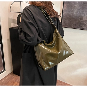 Détail du logo embossé sur le sac cabas en cuir verni brillant vert foncé