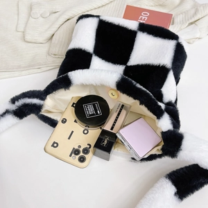 Detail of checkered plush handbag showing magnetic closure and interior storage space