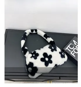 Détail de la texture en fausse fourrure pelucheuse et du motif floral sur le sac à main