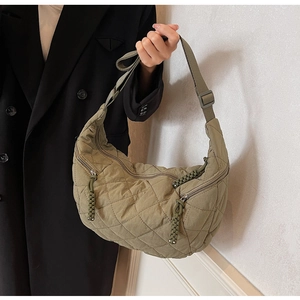 Detail view of the olive green quilted fabric shoulder bag with adjustable nylon strap