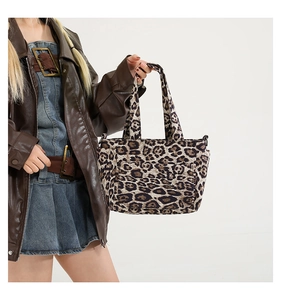 Detailed view of leopard print canvas tote bag with side metal D-ring and front pocket