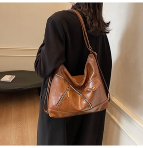 Detail showing high-quality brown PU leather texture and stylish zipper pocket on the bag