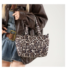 Detailed close-up of a leopard print canvas tote bag styled on a female fashion model