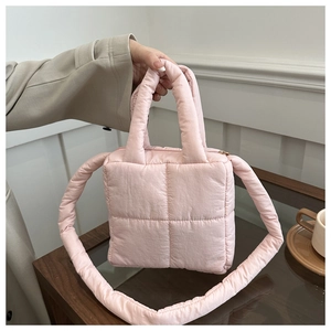 Dettaglio della borsa trapuntata rosa con texture, manico largo e tracolla lunga