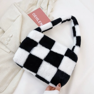 Detail of soft black and white checkerboard plush handbag with a fuzzy faux fur texture