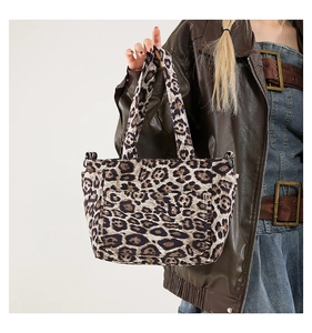 Close-up of leopard print canvas tote bag featuring front flap pocket and dual top handles