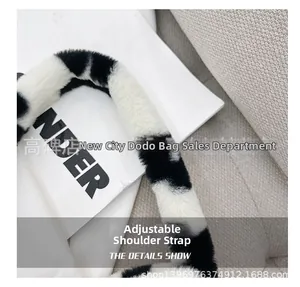 Detail of adjustable plush shoulder strap featuring a trendy black and white cow print texture