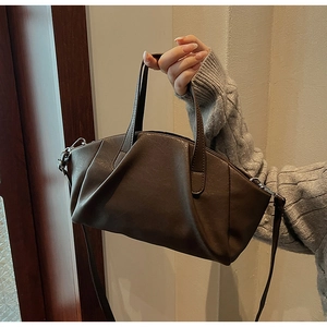 Detail of dark brown pleated PU leather handbag showing the unique texture and stitching