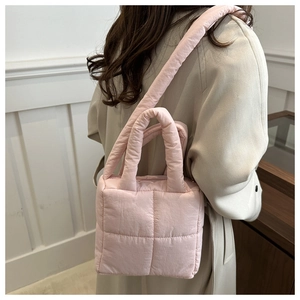 Detail view of pink quilted puffer bag showing the soft texture and square stitching