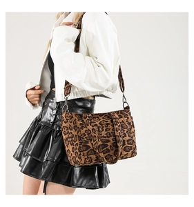 Detail of leopard print tote bag with black detachable wide shoulder strap on model