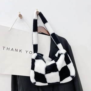 Close-up of fluffy black and white checkerboard plush handbag with soft faux fur texture