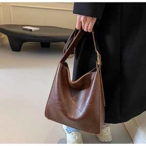 Detailed view of the dark brown hobo bag with a wide adjustable strap and golden buckle
