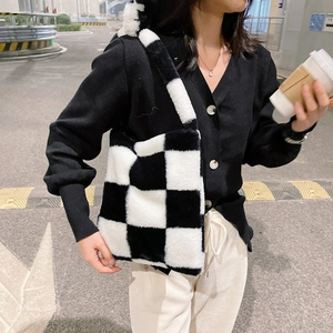 Minimalist black and white checkered plush tote bag for women in a chic city street setting