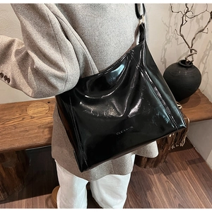Détail du sac à bandoulière noir brillant en PU avec logo CLEAROR embossé