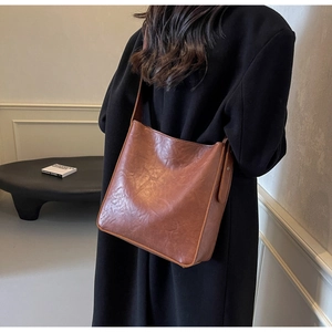 Detailed view of the matte brown faux leather texture on a vintage bucket shoulder bag