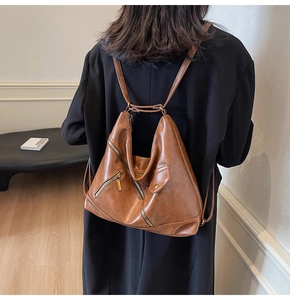 Brown PU leather backpack with vintage design and zipper details shown on a model