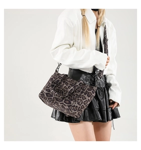 Close-up of leopard print tote bag with adjustable shoulder strap on white jacket