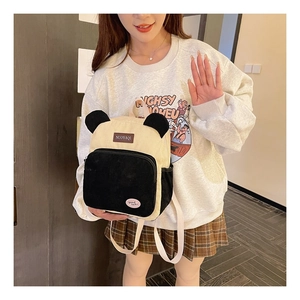 Detail of panda-shaped corduroy backpack with cute ears and minimalist embroidered labels