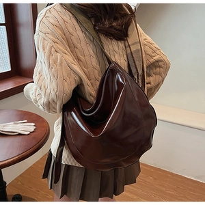 Dark brown PU leather half-moon shoulder bag with wide strap in a minimalist style