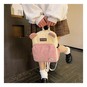 Detail of a velvet corduroy mini backpack with cute bear ears and brand label decoration