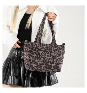 Close-up of leopard print tote bag with wide strap and metallic side ring attachments