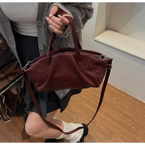 Detailed view of the dark red pleated PU leather handbag with silver metallic hardware