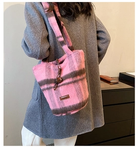 Detail of pink and brown plaid plush tote bag showing soft texture and woven knot accent