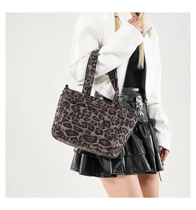 Detailed close-up of leopard print canvas tote bag with dual handles and fabric texture