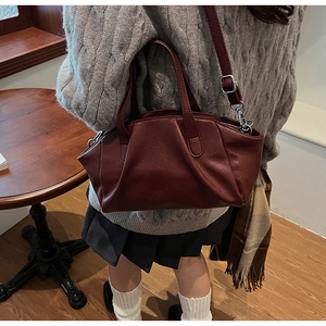 Detailed close-up of dark red PU leather bag featuring unique pleated design and texture