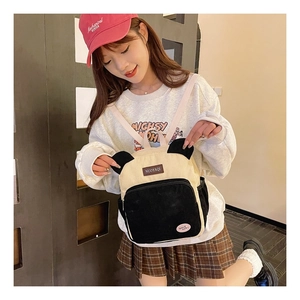 Detail of panda themed corduroy backpack featuring animal ears and brand logo patch
