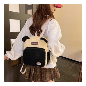 Detail of cute panda-style corduroy backpack showing plush ears and texture on person