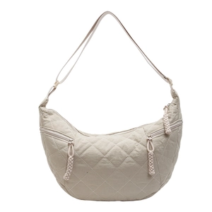 Cream quilted half-moon crossbody bag with diamond stitching and woven zipper pulls